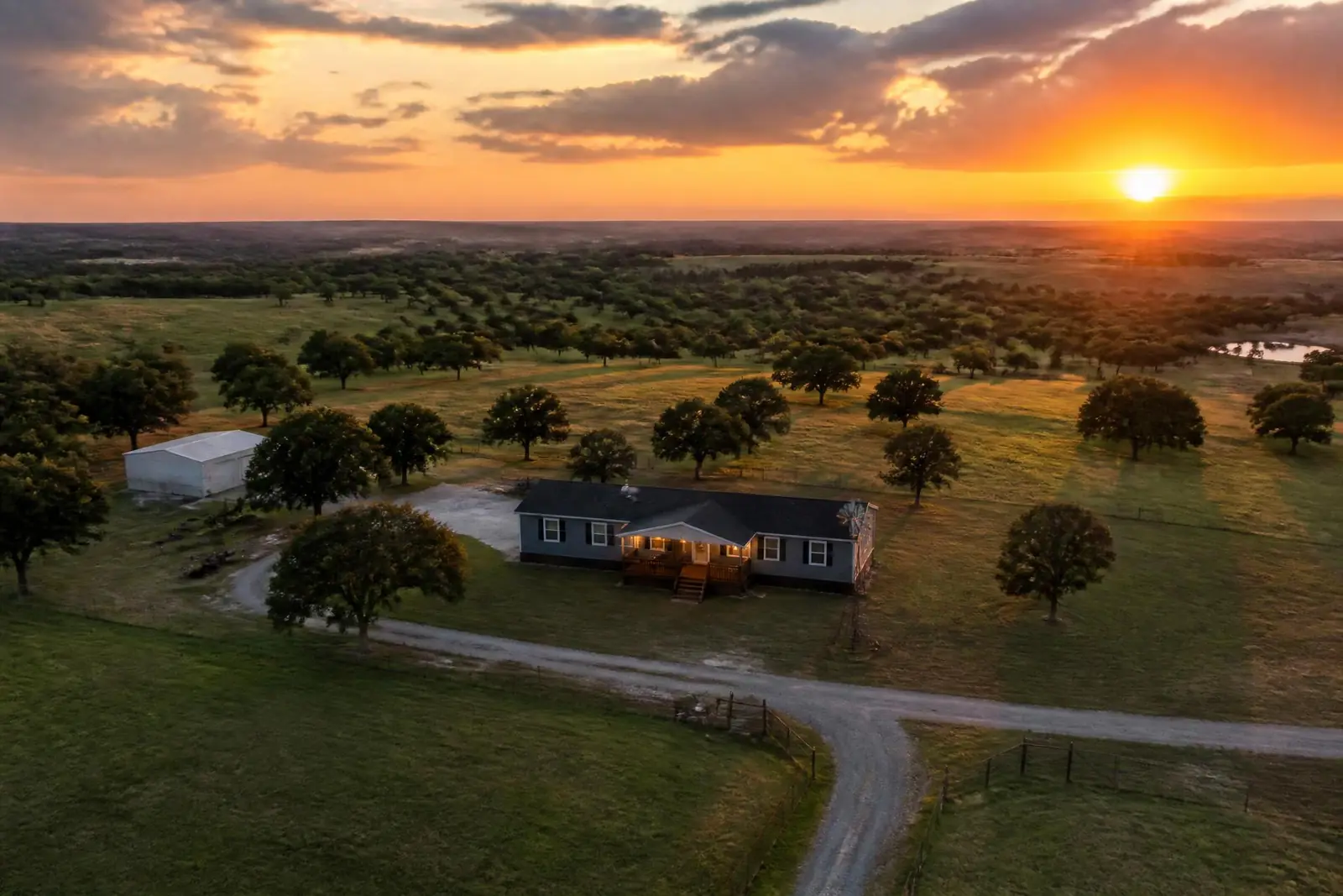 Aerial view of North Texas ranch land at sunset with a modern manufactured home